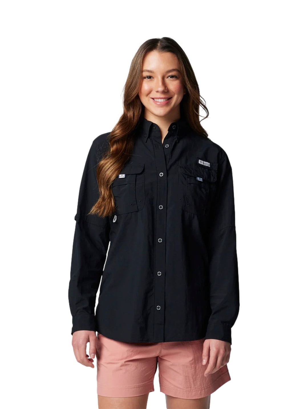 Mujer vistiendo una camisa Columbia PFG de manga larga en color negro con botones y bolsillos frontales.