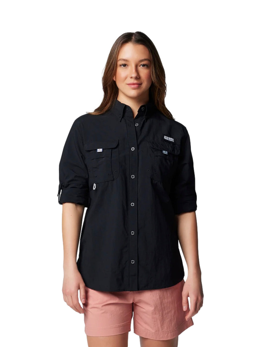 Mujer vistiendo una camisa Columbia PFG de manga larga en color negro con botones y bolsillos frontales.