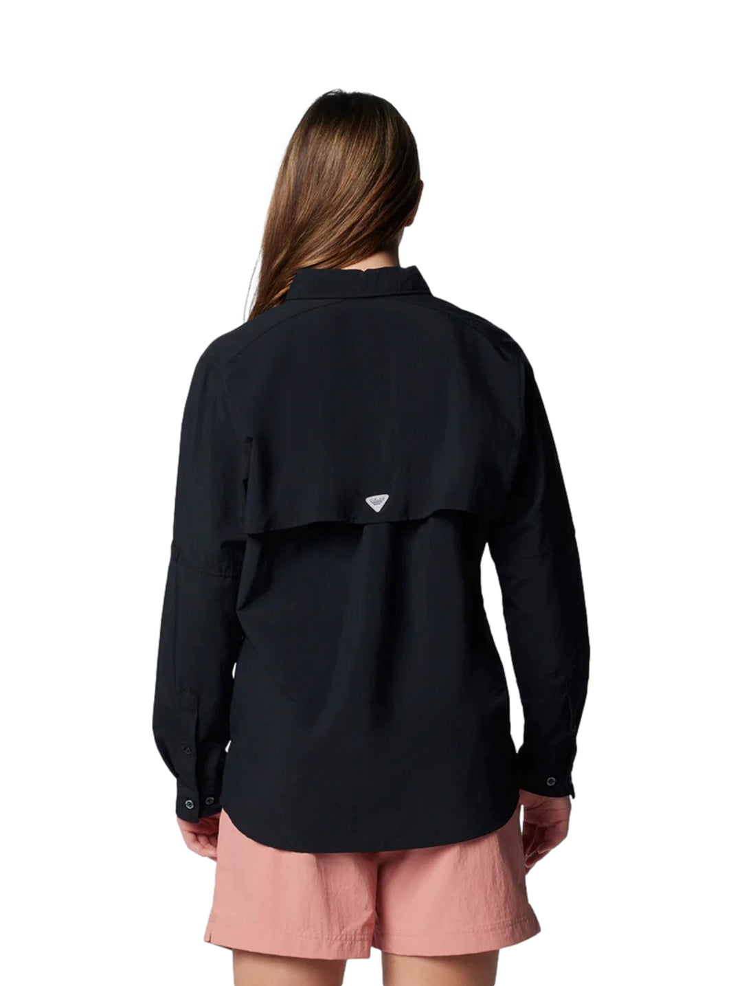 Mujer vistiendo una camisa Columbia PFG de manga larga en color negro con botones y bolsillos frontales.