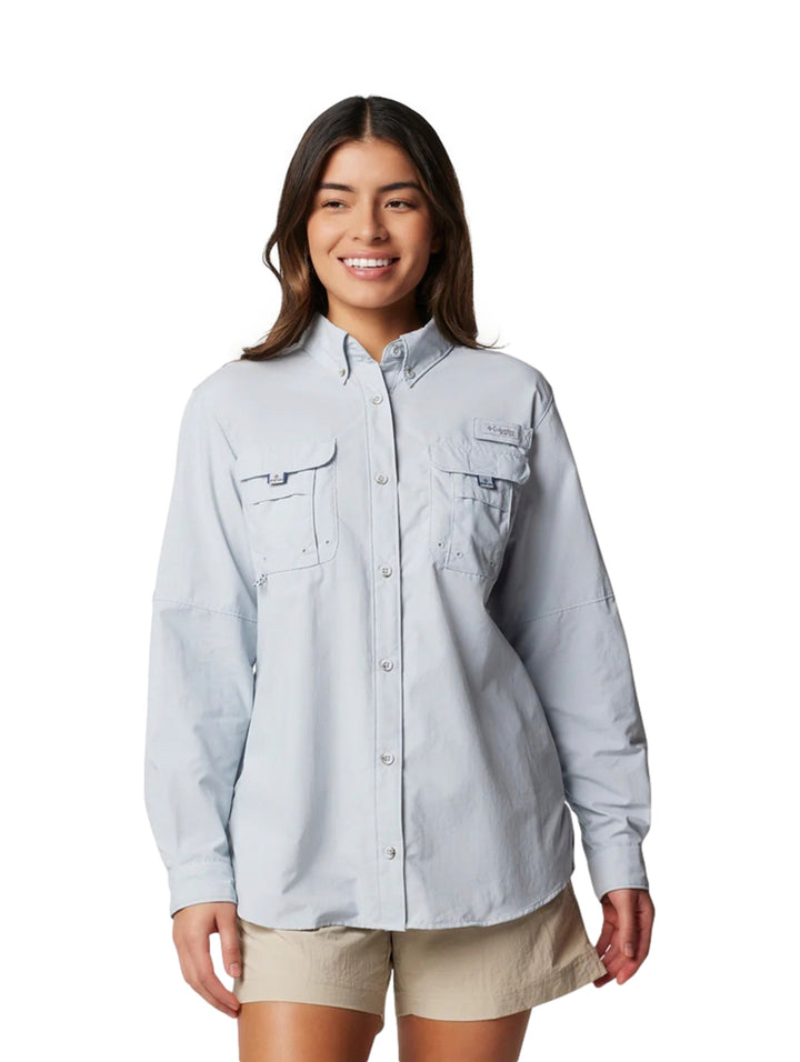 Mujer vistiendo una camisa Columbia de manga larga en color gris claro con bolsillos frontales.