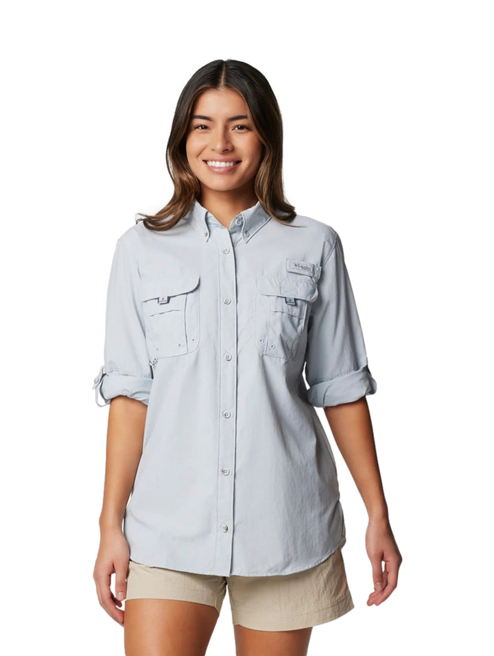 Mujer vistiendo una camisa Columbia de manga larga en color gris claro con bolsillos frontales.