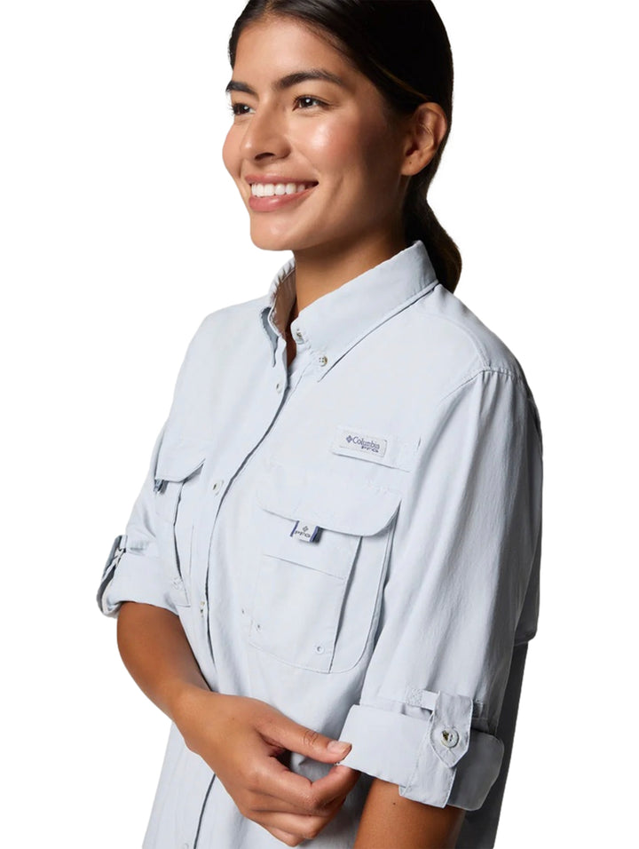 Mujer vistiendo una camisa Columbia de manga larga en color gris claro con bolsillos frontales.