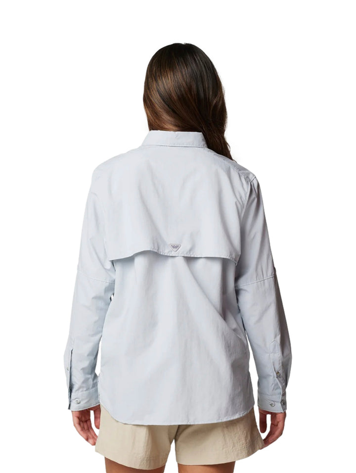 Mujer vistiendo una camisa Columbia de manga larga en color gris claro con bolsillos frontales.