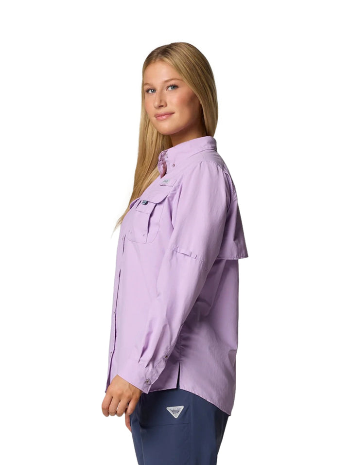 Mujer vistiendo una camisa Columbia PFG Bahama II de manga larga en color lila con bolsillos frontales.