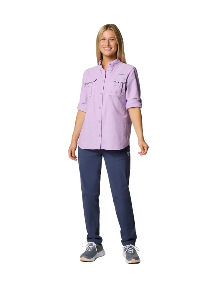 Mujer vistiendo una camisa Columbia PFG Bahama II de manga larga en color lila con bolsillos frontales.