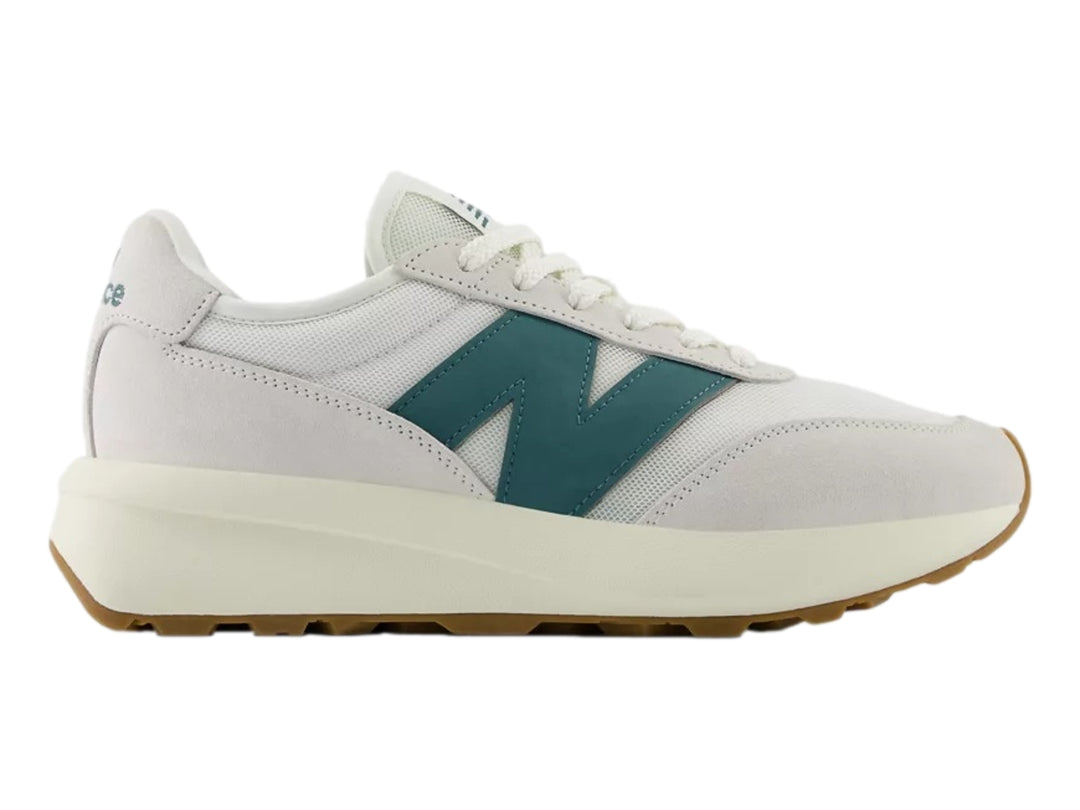 Tenis New Balance blancos con logo verde azulado y suela de goma color café.