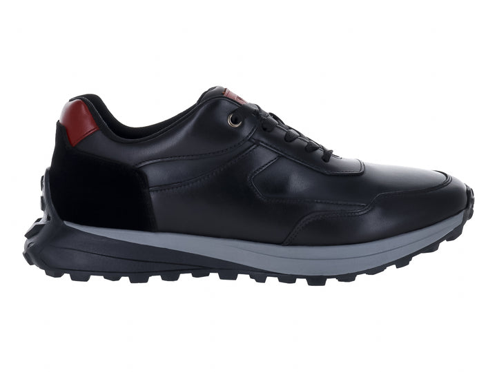 Tenis deportivos color negro con detalles en rojo y suela gris, vista lateral.