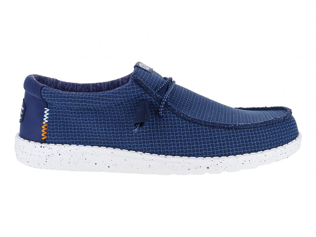 Zapato plano Hey Dude Wally Sport Mesh en color navy con suela blanca moteada y detalles en naranja.
