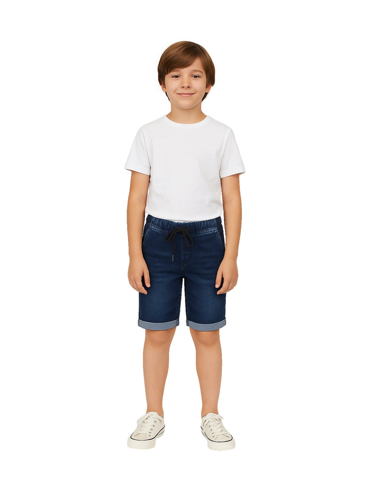 Niño vistiendo shorts de mezclilla azul con cintura elástica y dobles en el ruedo.