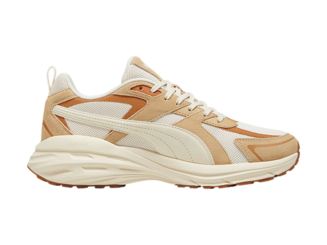 Tenis PUMA en color blanco y beige con suela gruesa y detalles de malla.