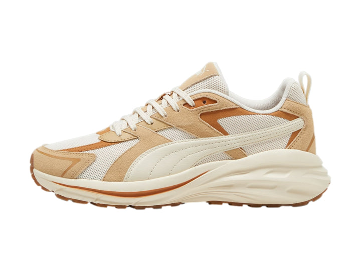 Tenis PUMA en color blanco y beige con suela gruesa y detalles de malla.