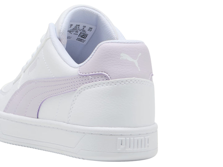 Tenis PUMA blancos con franja lateral y talón en color lila, diseño casual y suela blanca.
