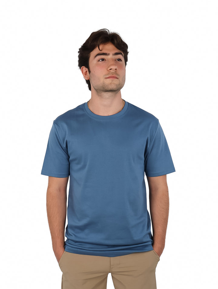 Hombre vistiendo una playera de manga corta color azul oscuro y cuello redondo.