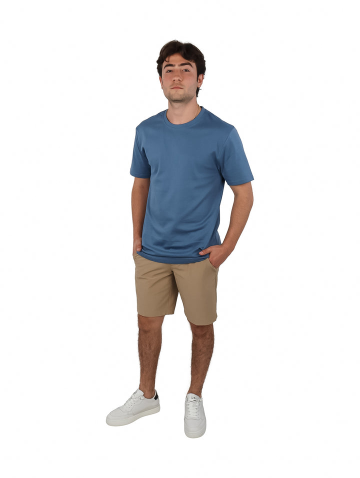 Hombre vistiendo una playera de manga corta color azul oscuro y cuello redondo.