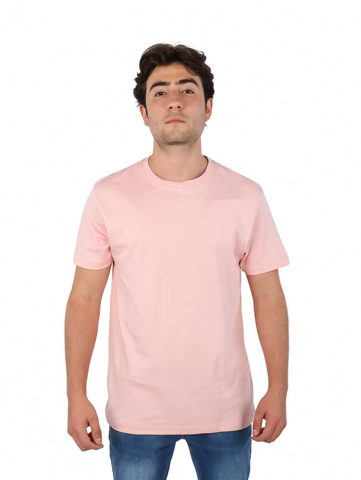 Hombre vistiendo una playera básica de color rosa claro con cuello redondo y manga corta.