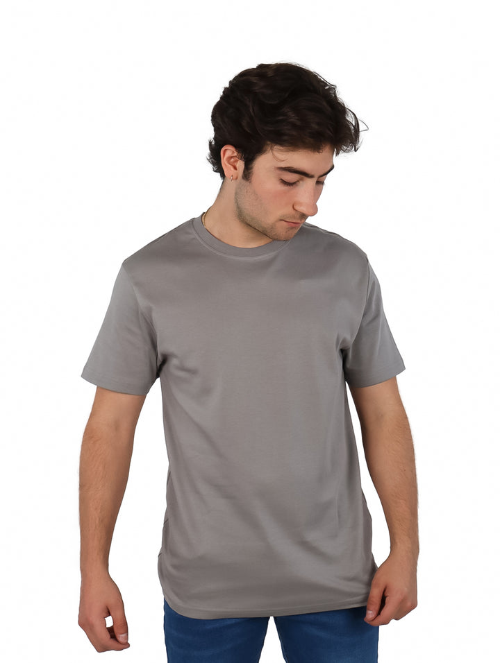 Hombre vistiendo una playera gris de manga corta y cuello redondo.