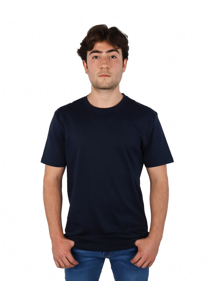 Hombre vistiendo una playera de manga corta color azul marino y pantalones de mezclilla