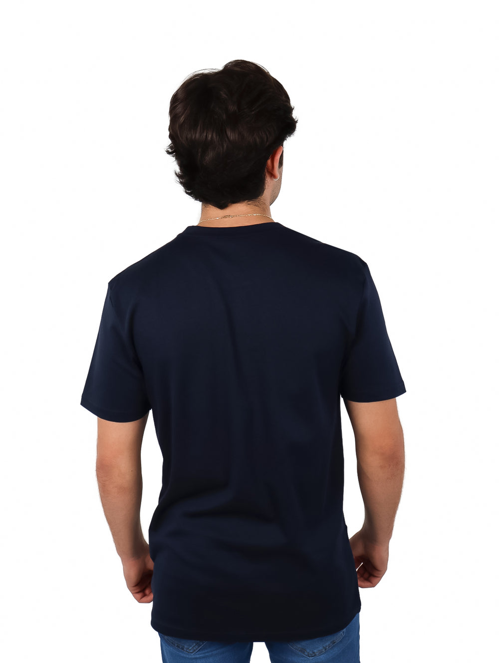 Hombre vistiendo una playera de manga corta color azul marino y pantalones de mezclilla
