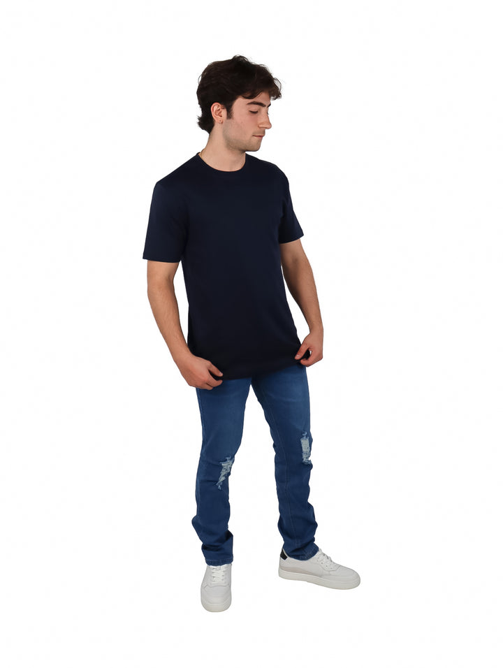 Hombre vistiendo una playera de manga corta color azul marino y pantalones de mezclilla