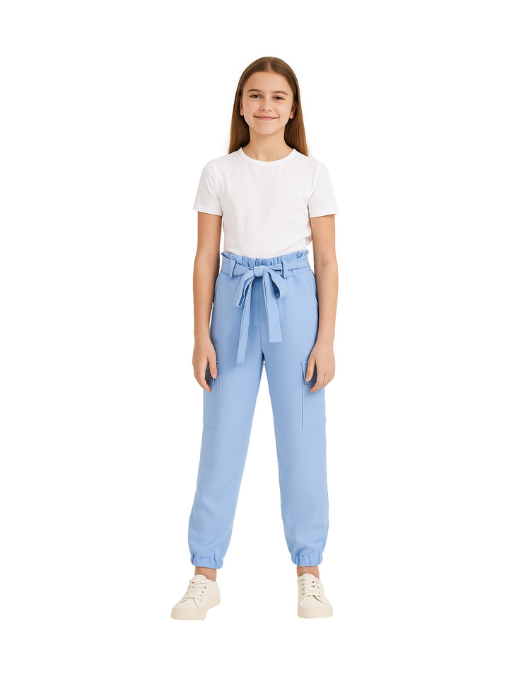 Niña vistiendo un pantalón tipo cargo color azul claro con cinturón de tela y camiseta blanca.