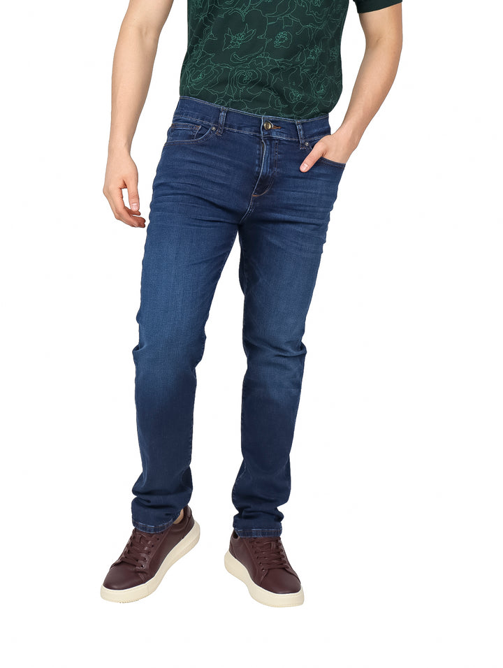 Hombre vistiendo jeans de mezclilla color azul claro con corte ajustado y calzado casual marrón.