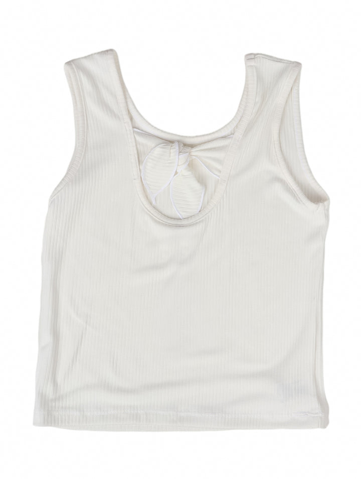 Blusa blanca sin mangas para niña con textura acanalada.