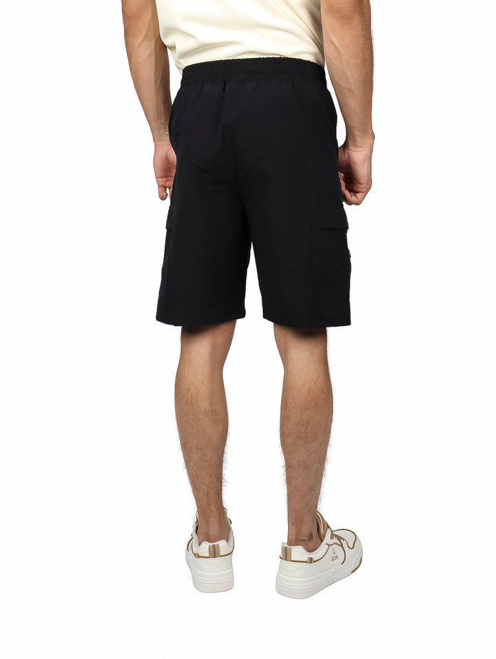 Hombre vistiendo short de surf color negro marca Yakuza con cintura elástica y cordón.