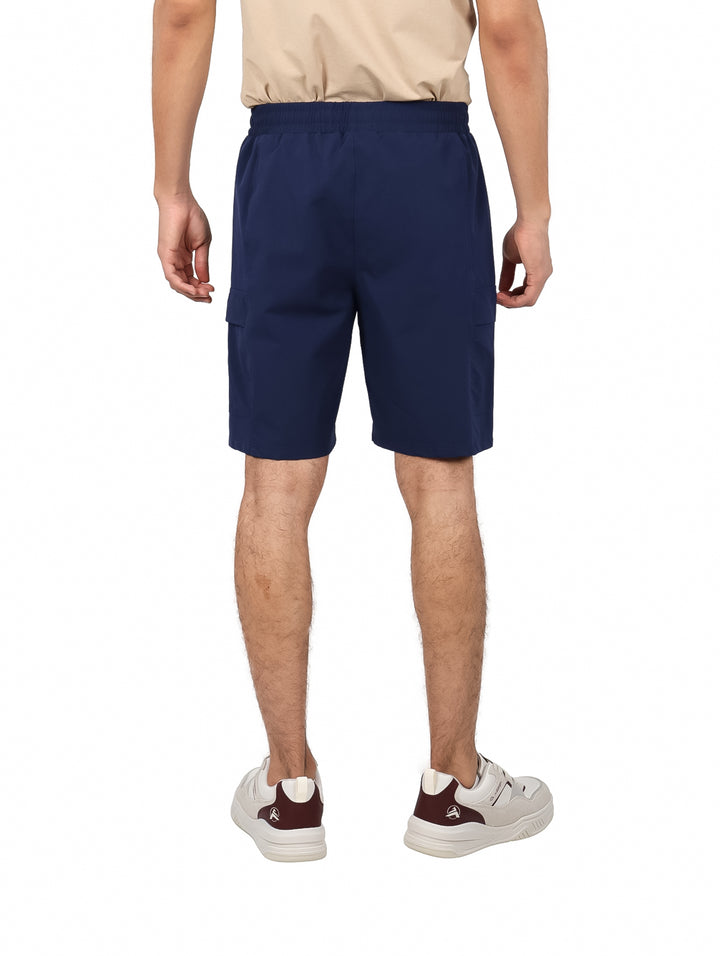 Hombre vistiendo shorts de surf color azul marino con cordón ajustable.