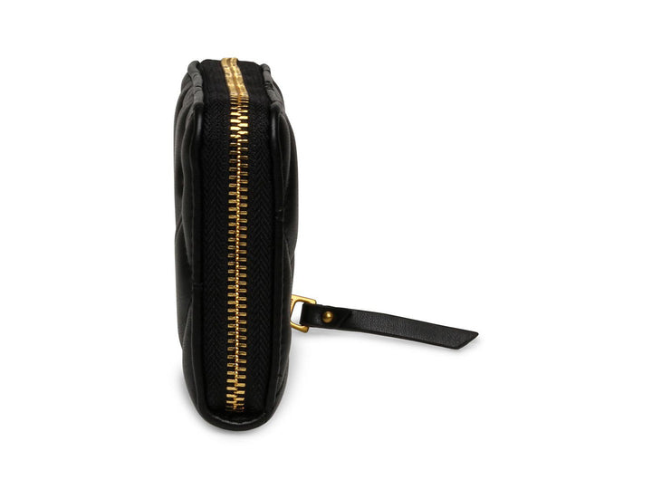 Cartera pequeña de Steve Madden en color negro con diseño acolchado y detalles metálicos dorados.