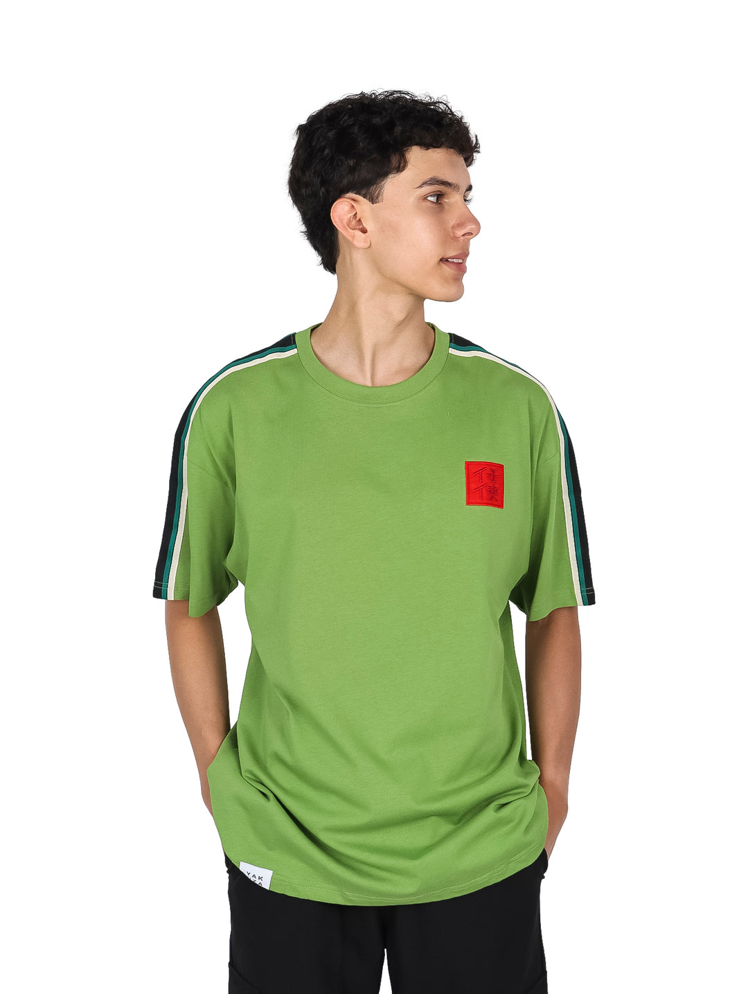 Hombre vistiendo playera color verde con franjas blancas y negras en las mangas y un pequeño detalle rojo al pecho.