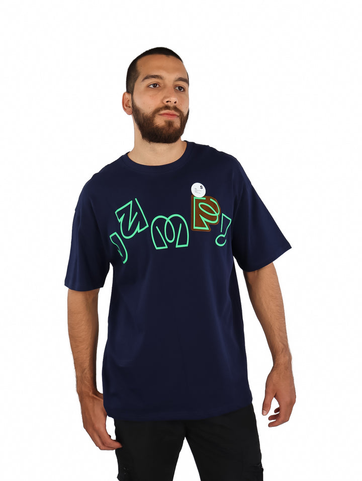 Hombre vistiendo playera azul marino de manga corta con estampado gráfico en color verde lima en el pecho.