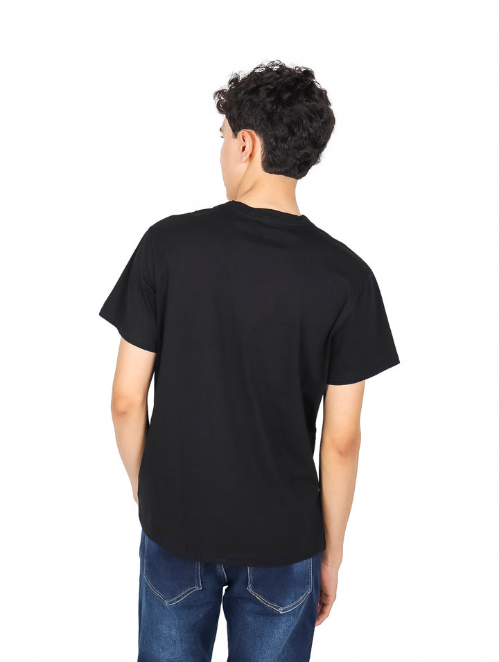 Hombre usando una playera negra de manga corta con un diseño gráfico blanco en el pecho.