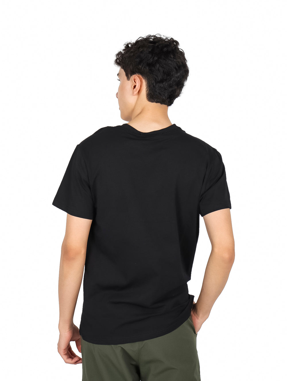 Hombre vistiendo una playera negra de manga corta con un pequeño estampado gráfico en el pecho.