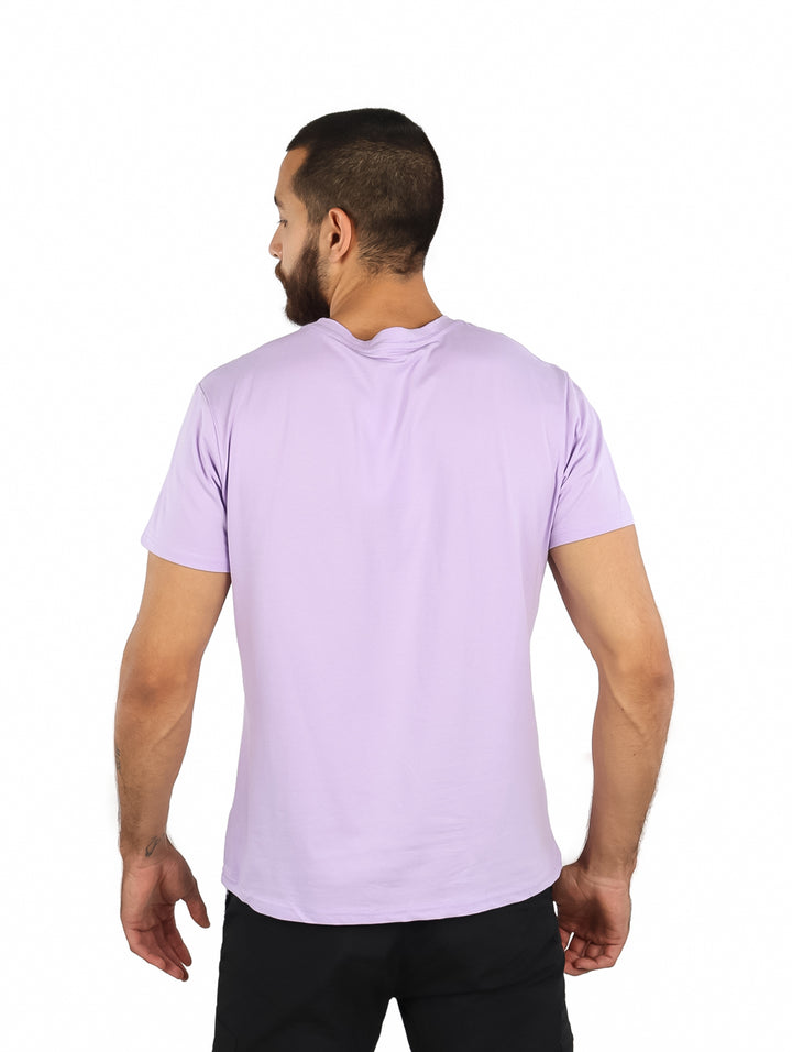 Hombre vistiendo una playera de manga corta color púrpura claro con un pequeño estampado en el pecho.