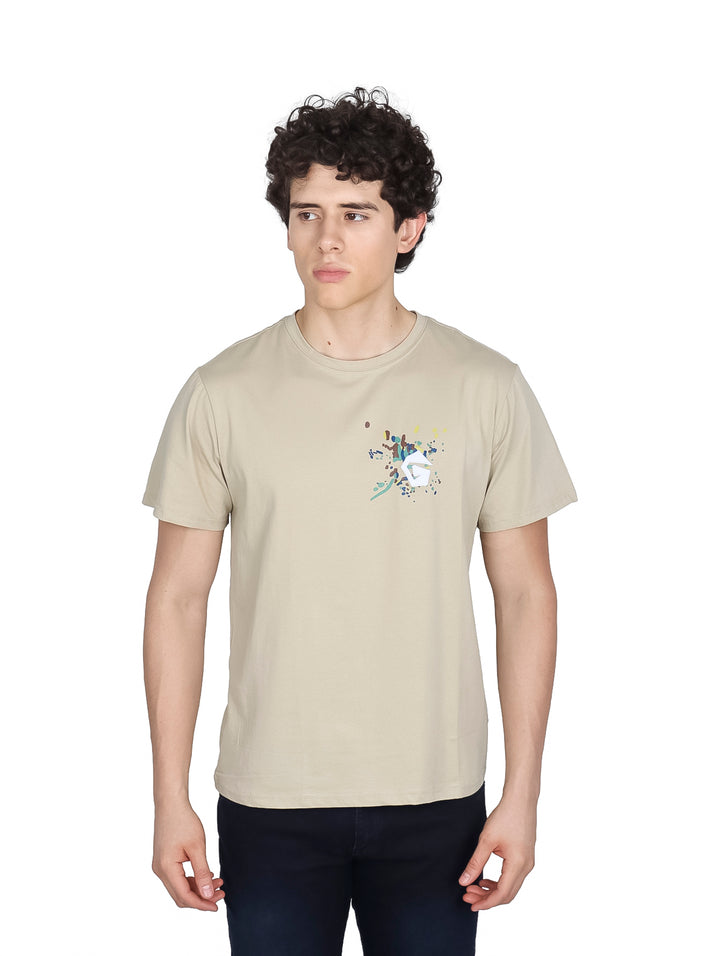 Hombre vistiendo una playera de manga corta color beige con un pequeño detalle gráfico en el pecho.