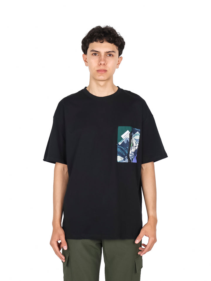 Hombre vistiendo playera negra de manga corta con estampado gráfico en el pecho.