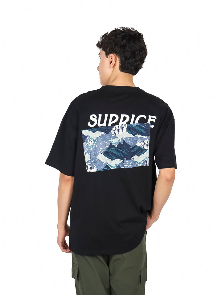 Hombre vistiendo playera negra de manga corta con estampado gráfico en el pecho.
