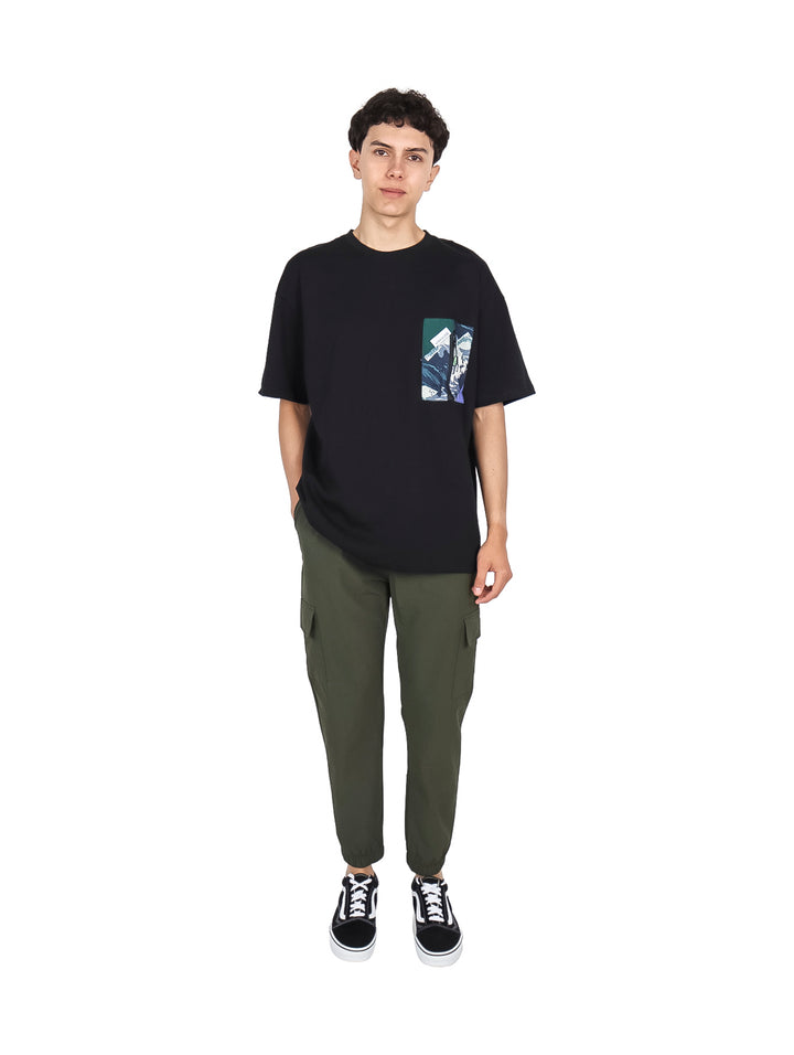Hombre vistiendo playera negra de manga corta con estampado gráfico en el pecho.