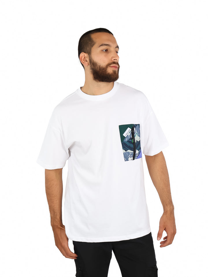 Hombre vistiendo playera blanca de manga corta con un bolsillo estampado en el pecho.