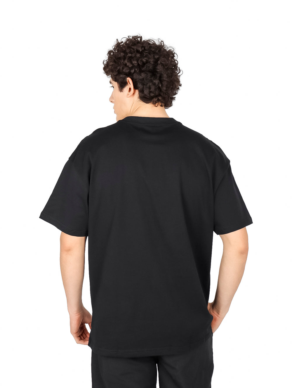Hombre vistiendo playera negra de manga corta con estampado gráfico en color ocre y blanco en el pecho.