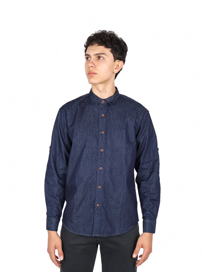 Hombre vistiendo camisa azul oscuro con pequeños puntos blancos, manga larga y cuello, estilo casual.