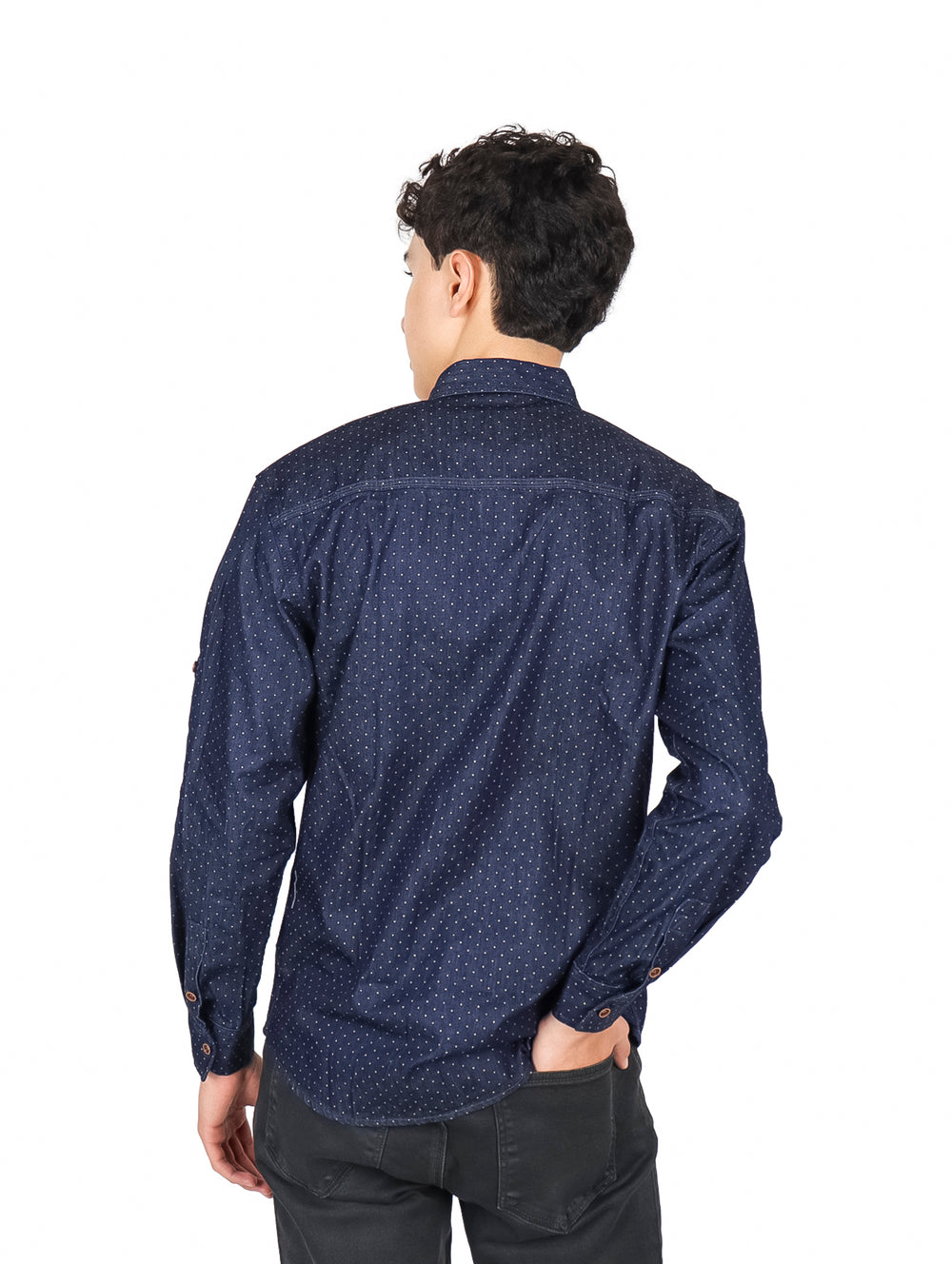 Hombre vistiendo camisa azul oscuro con pequeños puntos blancos, manga larga y cuello, estilo casual.