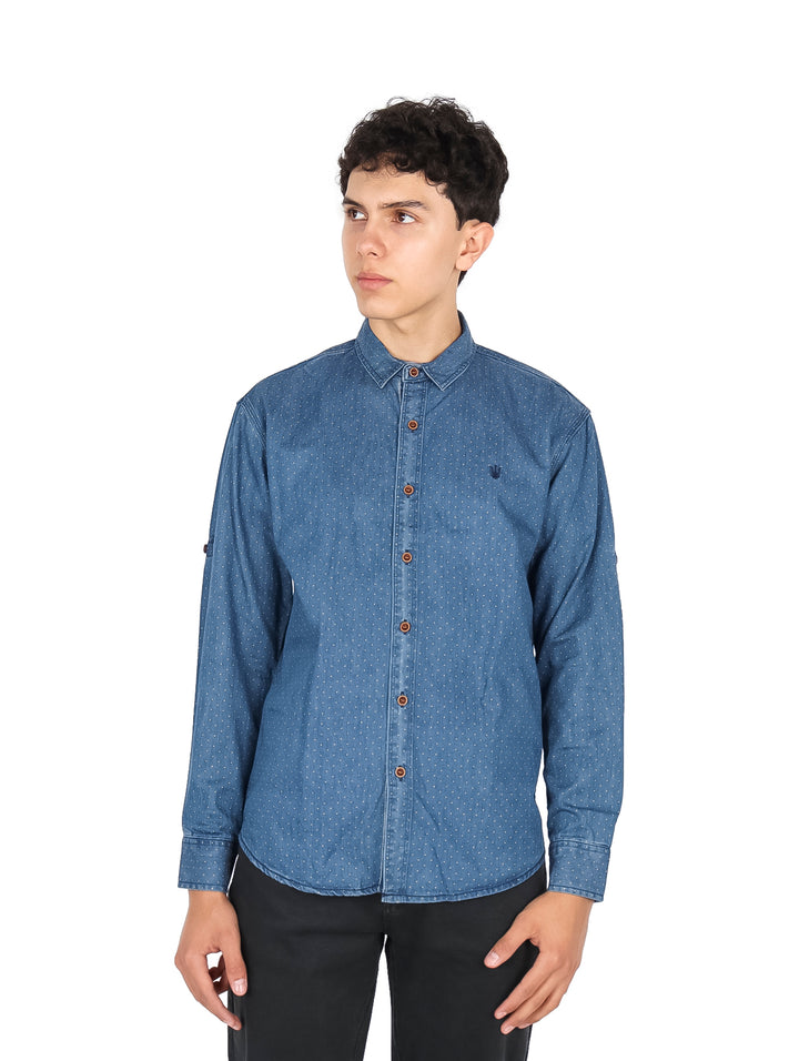 Hombre vistiendo camisa azul claro de manga larga con pequeños puntos blancos y botones frontales.