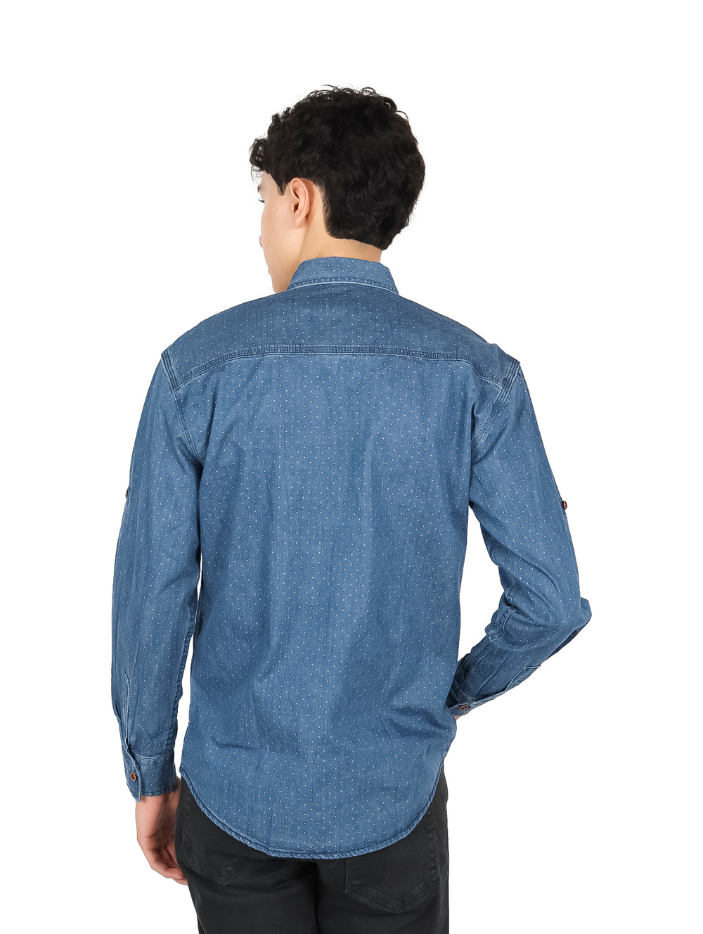 Hombre vistiendo camisa azul claro de manga larga con pequeños puntos blancos y botones frontales.