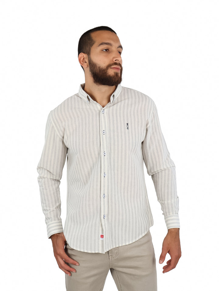 Hombre vistiendo una camisa de manga larga color beige con rayas verticales finas y botones frontales.