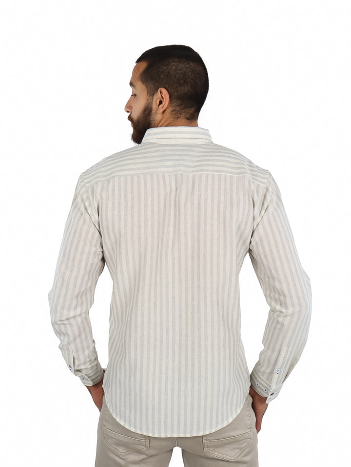 Hombre vistiendo una camisa de manga larga color beige con rayas verticales finas y botones frontales.