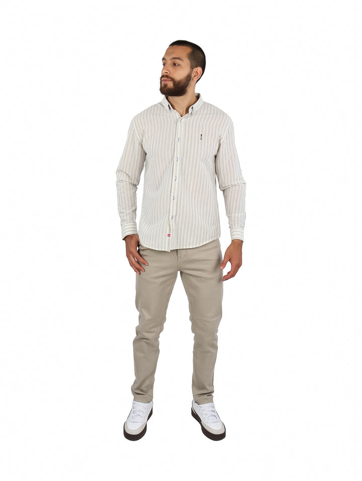 Hombre vistiendo una camisa de manga larga color beige con rayas verticales finas y botones frontales.