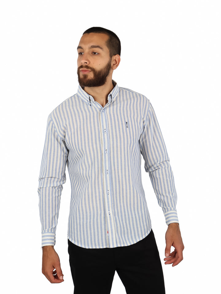Hombre vistiendo una camisa de manga larga con rayas verticales en color azul y blanco.
