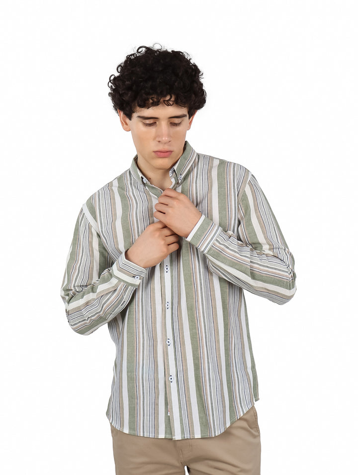 Hombre vistiendo una camisa de manga larga con rayas verticales en tonos verde, blanco y beige.