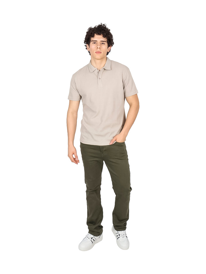 Hombre vistiendo una playera polo de color beige con cuello y manga corta.